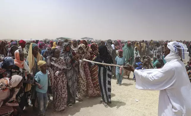 Refugees wait for food distribution at the Tine transit camp in Chad's Wadi Fara province Saturday, May 3, 2025. (AP Photo/Caitlin Kelly)