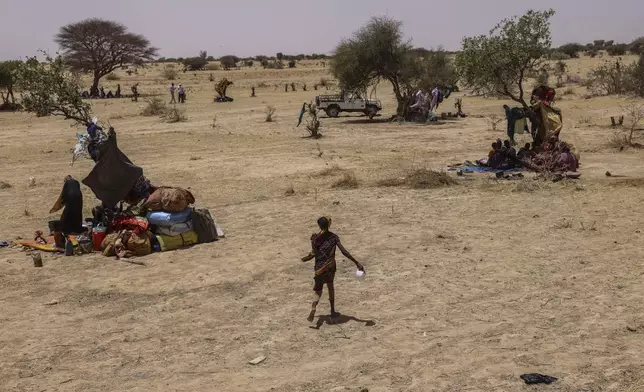 Refugees run for food in the Tine transit camp in Chad's Wadi Fara province Sunday, May 4, 2025. (AP Photo/Caitlin Kelly)
