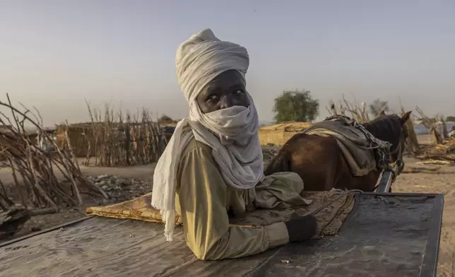 Asadiq Hamid Abdullah ferries goods for sale in and around Adre, Chad, Tuesday, May 6, 2025. (AP Photo/Caitlin Kelly)