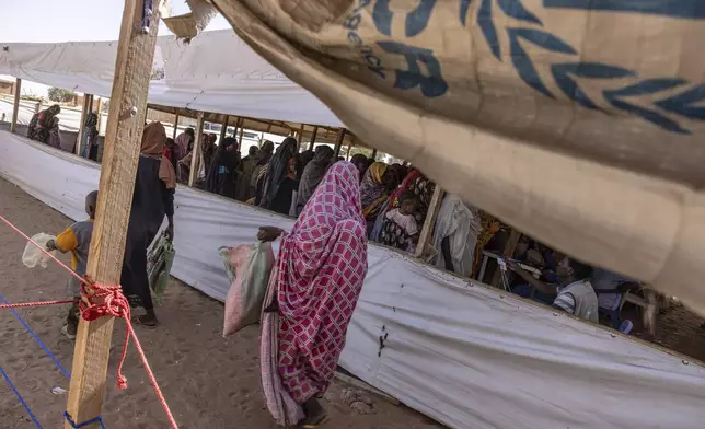 Refugees queue for food distribution in the Adre, Chad, transit camp, Thursday, May 8, 2025. (AP Photo/Caitlin Kelly)
