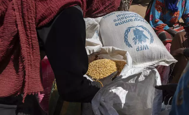 Refugees receive food supplies in the Adre, Chad, transit camp, Friday, May 9, 2025. (AP Photo/Caitlin Kelly)