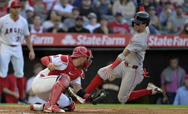Boston Red Sox's Marcelo Mayer, right, scores past Los Angeles Angels catcher Logan O'Hoppe on a sacrifice fly by Red Sox's Nate Eaton in the third inning of a baseball game Tuesday, June 24, 2025, in Anaheim, Calif. (AP Photo/Jayne Kamin-Oncea)