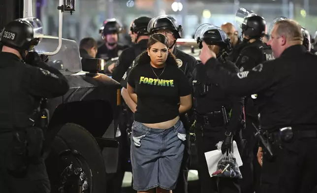 Law enforcement handcuff a woman during a protest on Thursday, June 12, 2025, in Los Angeles. (AP Photo/Wally Skalij)