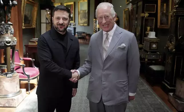 Britain's King Charles III, right, shakes hands with Ukrainian President Volodymyr Zelenskyy on the occasion of their private audience at Windsor Castle, England, Monday, June 23, 2025. (Jonathan Brady/Pool Photo via AP)