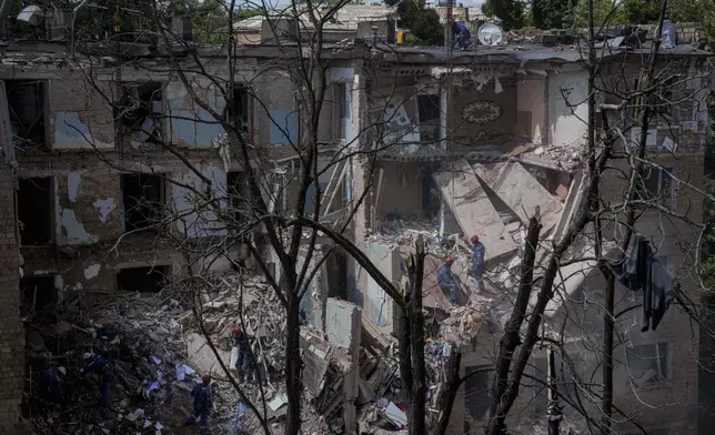 Rescue workers clear the rubble of a residential house destroyed by a Russian strike in Kyiv, Ukraine, on Monday, June 23, 2025. (AP Photo/Evgeniy Maloletka)