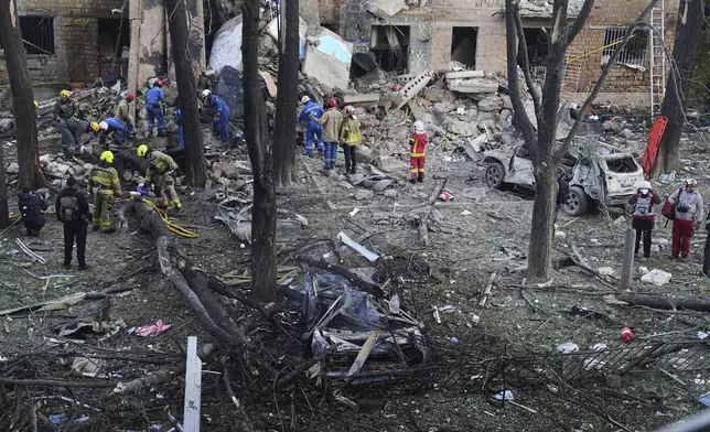 Firefighters work in a destroyed apartment building after a Russian attack in Kyiv, Ukraine, early Monday, June 23, 2025. (AP Photo/Efrem Lukatsky)