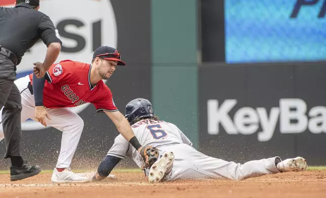 Cleveland Guardians' Will Wilson, left, is late with a tag as Houston Astros' Jake Meyers steals second during the second inning of a baseball game, Sunday June 8, 2025, in Cleveland. (AP Photo/Phil Long)