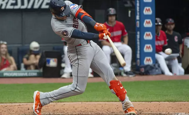 Houston Astros' Cam Smith hits a two-run RBI single off Cleveland Guardians starting pitcher Tanner Bibee during the seventh inning of a baseball game, Sunday June 8, 2025, in Cleveland. (AP Photo/Phil Long)