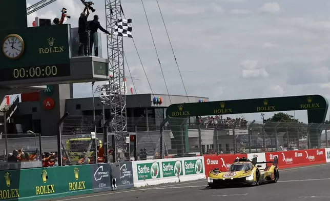 Robert Kubica of Poland in his AF Corse car a Ferrari 499P crosses the finish line to win the 24-hour Le Mans endurance race, Sunday June 15, 2025 in Le Mans, western France. (AP Photo/Jeremias Gonzalez)