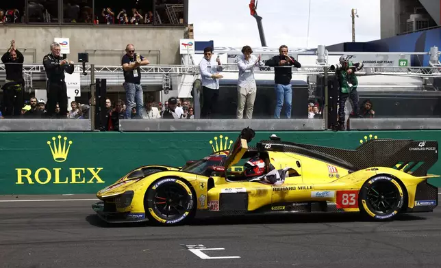 Robert Kubica of Poland in his AF Corse car a Ferrari 499P celebrates after crossing the finish line to win the 24-hour Le Mans endurance race, Sunday June 15, 2025 in Le Mans, western France. (AP Photo/Jeremias Gonzalez)