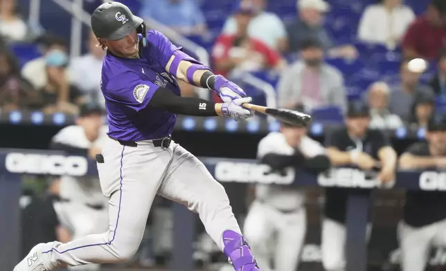 Colorado Rockies' Hunter Goodman hits a solo home run during the eighth inning of a baseball game against the Miami Marlins, Tuesday, June 3, 2025, in Miami. (AP Photo/Lynne Sladky)