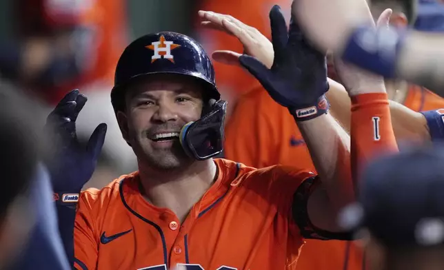 Houston Astros designated hitter Jose Altuve is congratulated in the dugout after hitting a solo home run during the fourth inning of a baseball game against the Minnesota Twins, Friday, June 13, 2025, in Houston. (AP Photo/Kevin M. Cox)