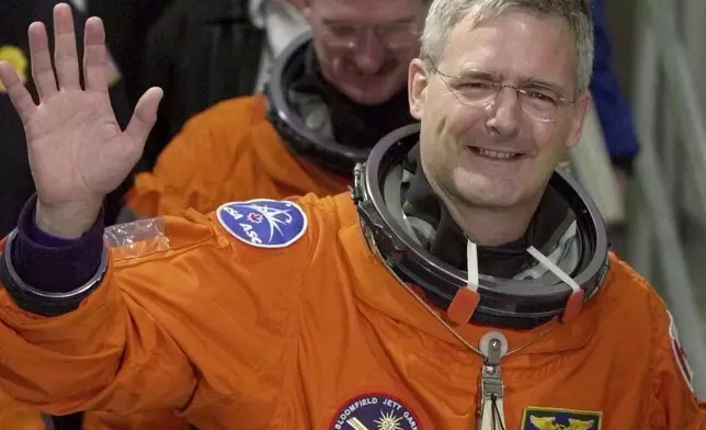 FILE - Canadian mission specialist Marc Garneau waves to photographers as he leaves the Operations and Checkout Building on Merritt Island, Fla., Nov. 30, 2000. (AP Photo/Chris O'Meara, File)