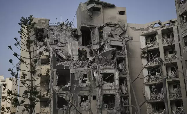 Israeli soldiers and rescue team search for survivors amid the rubble of residential buildings destroyed by an Iranian missile strike that killed several people, in Beersheba, Israel, on Tuesday, June 24, 2025. (AP Photo/Leo Correa)