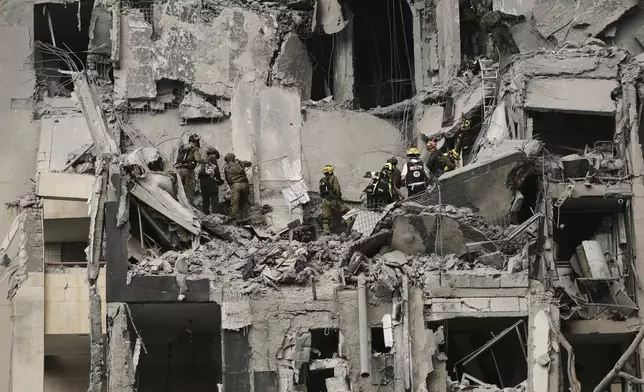 Israeli soldiers and rescue team search for survivors amid the rubble of residential buildings destroyed by an Iranian missile strike that killed several people, in Beersheba, Israel, on Tuesday, June 24, 2025. (AP Photo/Leo Correa)