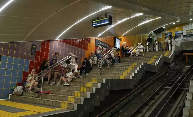 People take shelter in an underground metro station as air raid sirens warn of incoming Iranian strikes in Haifa, Israel, Tuesday, June 24, 2025. (AP Photo/Baz Ratner)