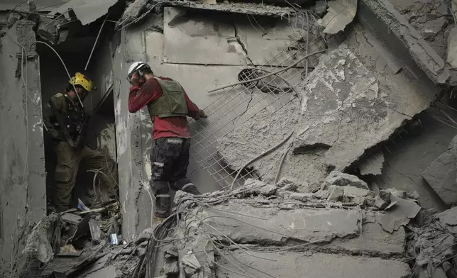 Israeli soldiers and rescue team search for survivors amid the rubble of residential buildings destroyed by an Iranian missile strike that killed several people, in Beersheba, Israel, on Tuesday, June 24, 2025. (AP Photo/Leo Correa)