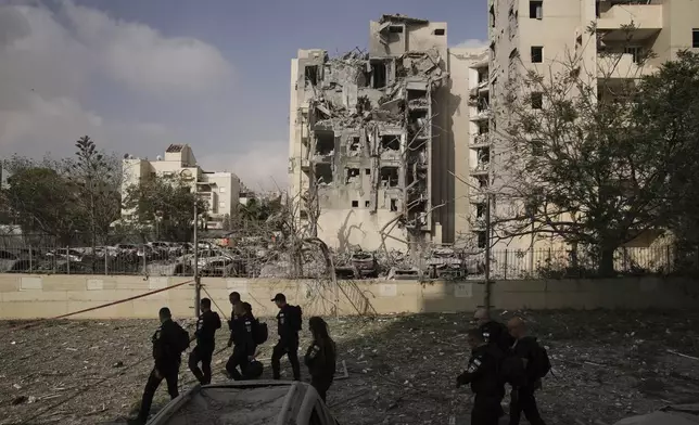 Police officers inspect residential buildings destroyed by an Iranian missile strike that killed several people, in Beersheba, Israel, on Tuesday, June 24, 2025. (AP Photo/Leo Correa)