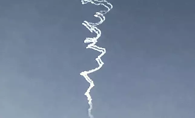 Smoke trails from Israeli air defense system are seen in the sky as it intercepts missiles launched during an Iranian attack, seen from Hadera, Israel, on Tuesday, 24 June 2025. (AP Photo/Ariel Schalit)