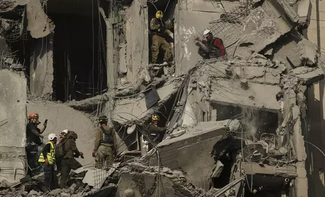 Israeli soldiers and rescue team search for survivors amid the rubble of residential buildings destroyed by an Iranian missile strike that killed several people, in Beersheba, Israel, on Tuesday, June 24, 2025. (AP Photo/Leo Correa)