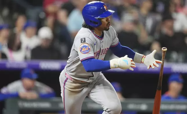 New York Mets' Francisco Lindor follows the flight of his single off Colorado Rockies relief pitcher Jimmy Herget in the eighth inning of a baseball game Saturday, June 7, 2025, in Denver. (AP Photo/David Zalubowski)