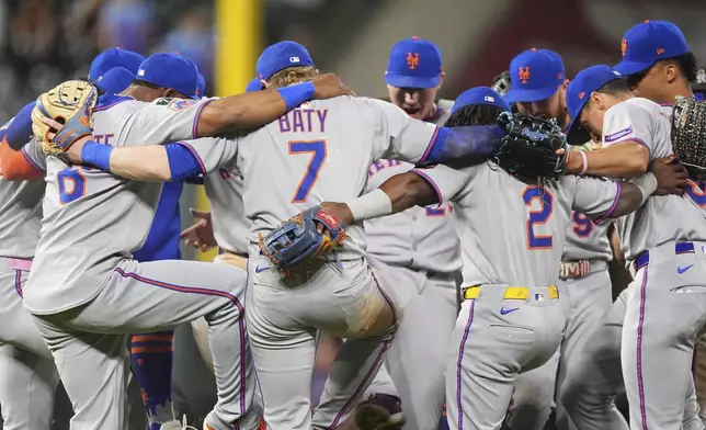 Members of the New York Mets gather to celebrate after defeating the Colorado Rockies in a baseball game Saturday, June 7, 2025, in Denver. (AP Photo/David Zalubowski)