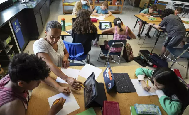 Art teacher Lindsay Johnson, second from left, teaches students how to ask ChatGPT for help during a summer class at Roosevelt Middle School, Wednesday, June 25, 2025, in River Forest, Ill. (AP Photo/Nam Y. Huh)