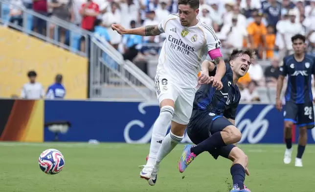 Real Madrid's Federico Valverde, left, and Pachuca's Agustin Palavecino battle for the ball during the Club World Cup Group H soccer match between Real Madrid and CF Pachuca in Charlotte, N.C., Sunday, June 22, 2025. (AP Photo/Chris Carlson)