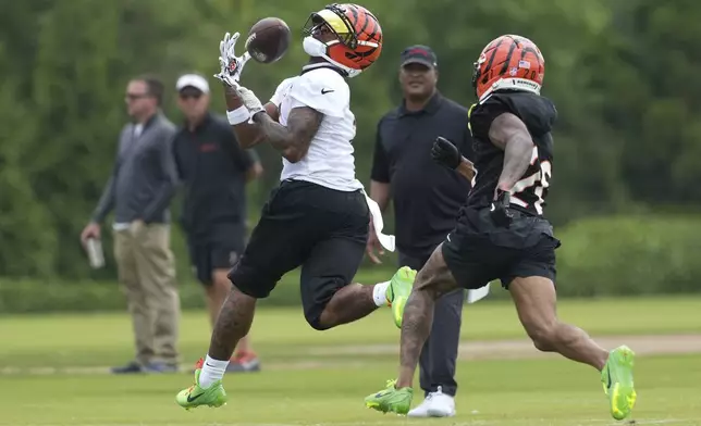 Cincinnati Bengals wide receiver Ja'Marr Chase (1) catches a pass as cornerback DJ Turner II (20) defends during NFL football practice Tuesday, June 3, 2025, in Cincinnati. (AP Photo/Kareem Elgazzar)