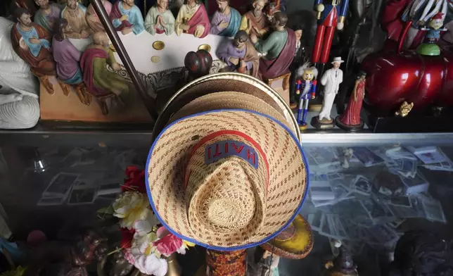 Haiti-decorated hats are displayed for sale among other items, inside 3x3 Santa Barbara Botanica in Miami's Little Haiti neighborhood, Friday, June 6, 2025. (AP Photo/Rebecca Blackwell)