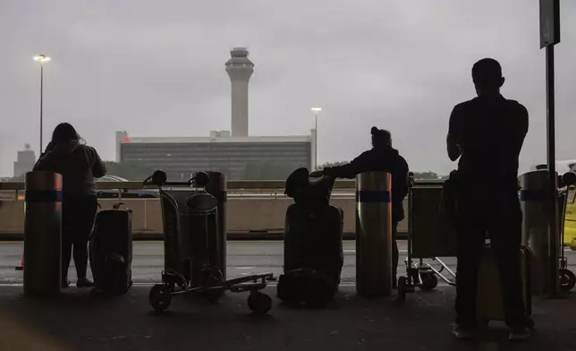 People wait for a taxi at the international terminal at Newark Liberty International Airport, Monday, June 9, 2025, in New Jersey. (AP Photo/Yuki Iwamura)