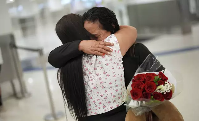 Vicenta Aguilar, right, hugs her son's girlfriend as Aguilar and her husband arrive from Guatemala to see their son for the first time in 22 years and to meet their two grandchildren grandchildren, at Miami International Airport, Monday, June 9, 2025, in Miami. (AP Photo/Rebecca Blackwell)