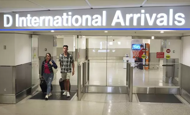 Luis Hernandez, 33, right, who traveled to Cuba for the Weekend arrives at Miami International Airport, Monday, June 9, 2025, in Miami. (AP Photo/Rebecca Blackwell)