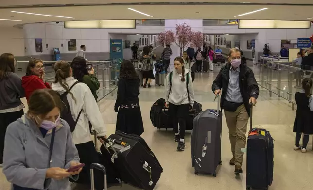 People carrying suitcases arrive from international flight at Newark Liberty International Airport, Monday, June 9, 2025, in New Jersey. (AP Photo/Yuki Iwamura)