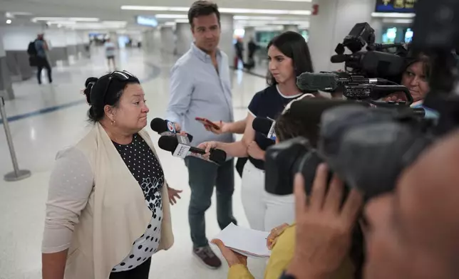 Magda Moreno, 58, a Cuban-American who had just arrived back from Havana, speaks to journalists at Miami International Airport, Monday, June 9, 2025, in Miami. (AP Photo/Rebecca Blackwell)