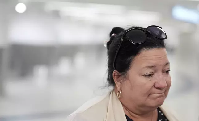 Magda Moreno, 58, a Cuban-American who had just arrived back from Havana, reacts as she speaks to journalists about a travel ban affecting some Cubans, at Miami International Airport, Monday, June 9, 2025, in Miami. (AP Photo/Rebecca Blackwell)
