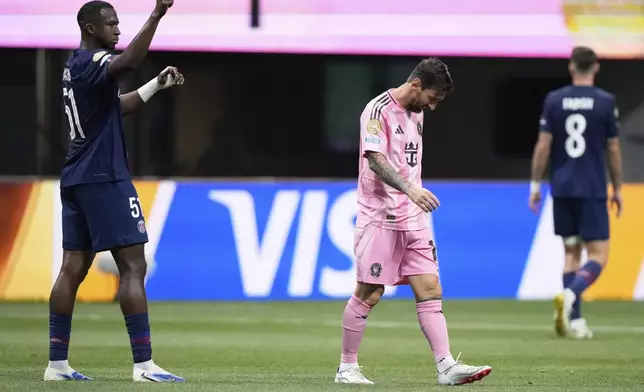 Paris Saint-Germain's Willian Pacho, left, signals as Inter Miami's Lionel Messi, center, walks away during the Club World Cup round of 16 soccer match between PSG and Inter Miami in Atlanta, Sunday, June 29, 2025. (AP Photo/Brynn Anderson)