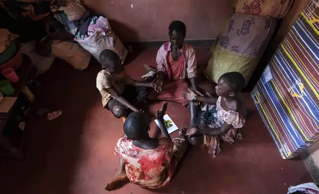 Children of Simon Tigawalana play while sitting on a clay-based earthen floor made by EarthEnable on May 16, 2025, in Jinja, Uganda. (AP Photo/Hajarah Nalwadda)