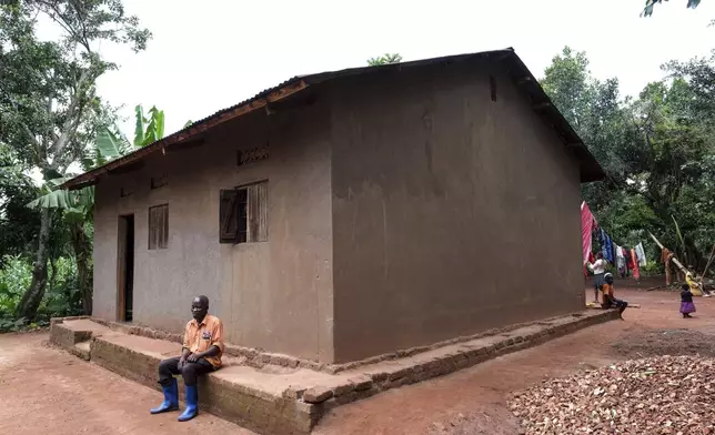 Simon Tigawalana rests in front of his house with clay-based earthen floors by EarthEnable on May 16, 2025, in Jinja, Uganda. (AP Photo/Hajarah Nalwadda)