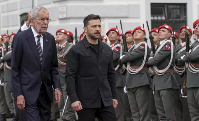 Ukraine's President Volodymyr Zelenskyy, right, and Austrian President Alexander van Der Bellen walk past the honour guard in Vienna, Austria, Monday, June 16, 2025. (AP Photo/Heinz-Peter Bader)