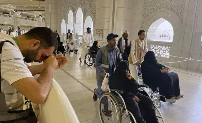 A Muslim pilgrim prays as others walk at the Kaaba, the cubic building at the Grand Mosque, during the annual Hajj pilgrimage, in the Muslim holy city of Mecca, Saudi Arabia, Wednesday, June 4, 2025. (AP Photo/Amr Nabil)
