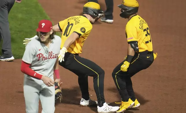 Pittsburgh Pirates' Nick Gonzales, right, celebrates with Bryan Reynolds (10) after hitting a walk-off sacrifice fly ball off Philadelphia Phillies pitcher Jordan Romano, driving in the game-winning run during the bottom of the ninth inning of a baseball game in Pittsburgh, Friday, June 6, 2025. (AP Photo/Gene J. Puskar)