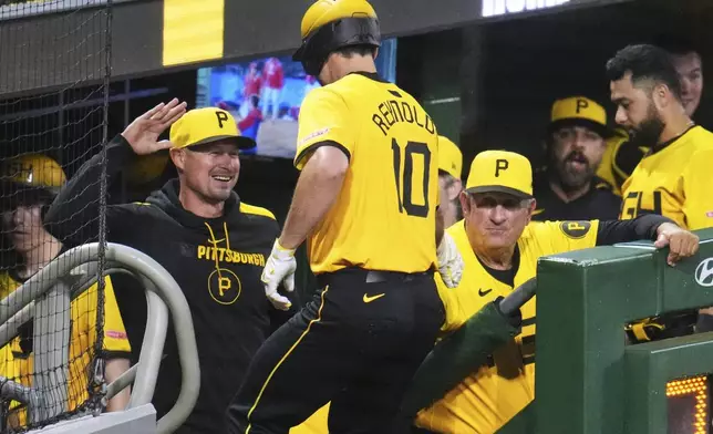 Pittsburgh Pirates' Bryan Reynolds (10) is greeted at the dugout steps by manager Don Kelly, left, and coach Gene Lamont, right, after hitting a solo home run off Philadelphia Phillies pitcher Tanner Banks during the third inning of a baseball game in Pittsburgh, Friday, June 6, 2025. (AP Photo/Gene J. Puskar)