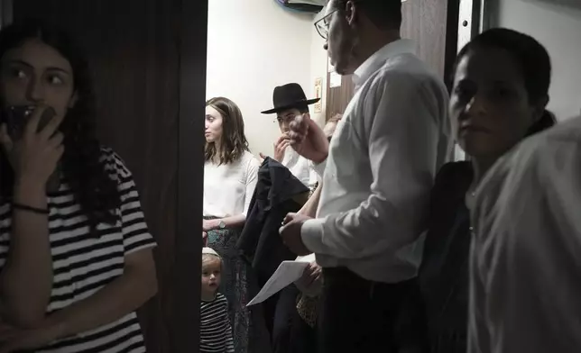People take shelter during sirens warning of incoming fire at Israel's Magen David Adom emergency service during a blood drive to prepare for mass casualties in the event of strikes by Iran, in Jerusalem, Saturday, June 14, 2025. (AP Photo/Maya Alleruzzo)