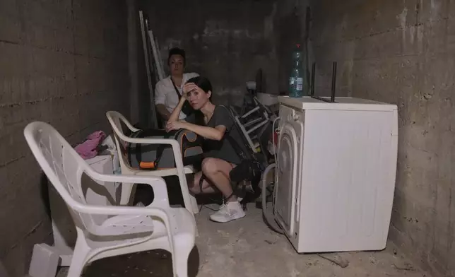 Israelis stay in a shelter of a residential area that was hit by a missile fired from Iran, in the central Israeli city of Bat Yam, early Sunday, June 15, 2025. (AP Photo/Ohad Zwigenberg)