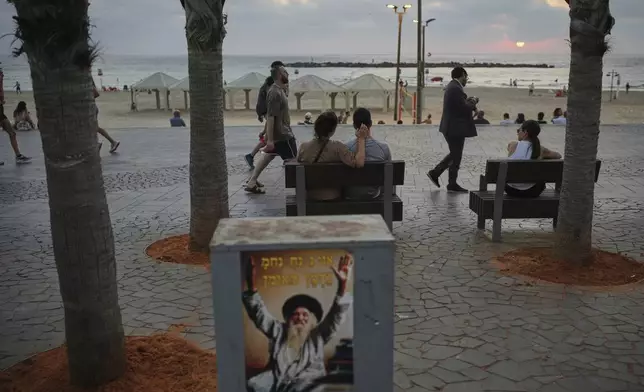 People walk along the beachfront promenade in Tel Aviv, Israel, on Saturday, June 14, 2025. (AP Photo/Ohad Zwigenberg)