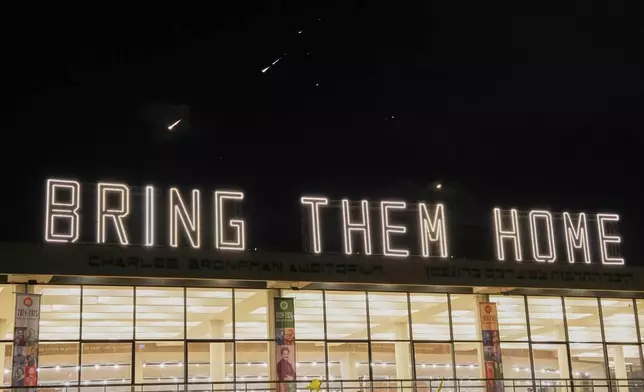 Missiles illuminate the night sky in central Israel during an Iranian missile attack, on Saturday, June 14, 2025. (AP Photo/Baz Ratner)