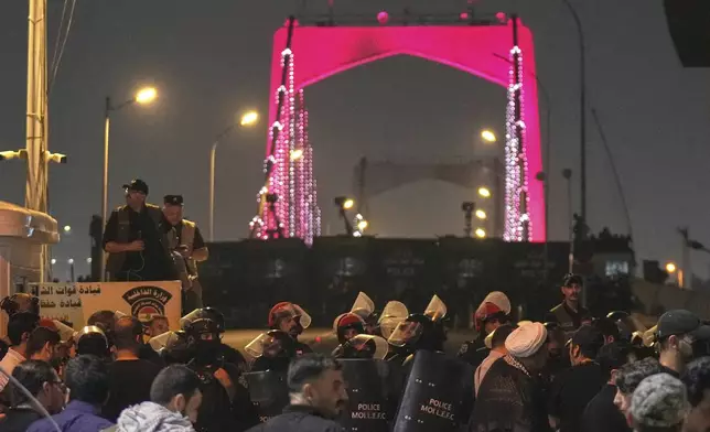 Iraqi security forces close a bridge leading to the Green Zone where the U.S. embassy is located, during a protest against Israeli attacks on multiple cities across Iran, in Baghdad, Iraq, Saturday, June 14, 2025. (AP Photo/Hadi Mizban)