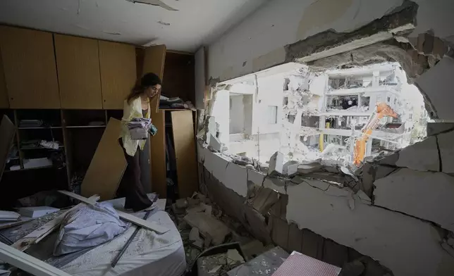 Maryn Mahtiov gathers her belongings from her apartment in Bat Yam, central Israel, after it was struck by an Iranian missile on Sunday, June 15, 2025. (AP Photo/Baz Ratner)