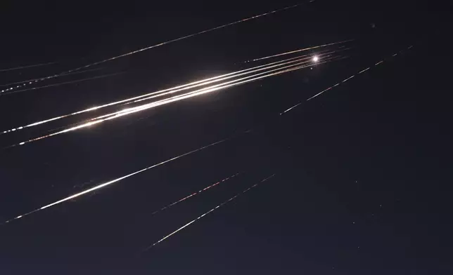 Missiles illuminate the night sky during an Iranian missile attack in Jerusalem, early Sunday, June 15, 2025. (AP Photo/Mahmoud Illean)